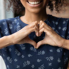 woman forming heart symbol with her hands